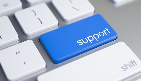 Blue keyboard key with the word "support" in white text, standing out among white keys on a keyboard