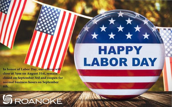 Patriotic Labor Day announcement with American flags and a round badge saying "Happy Labor Day" on a wooden surface