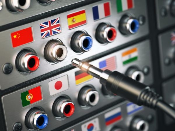 Multilingual audio input panel with national flags and color-coded ports, featuring a professional audio jack in focus