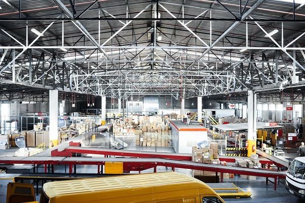Large distribution warehouse interior with pallets and industrial conveyors