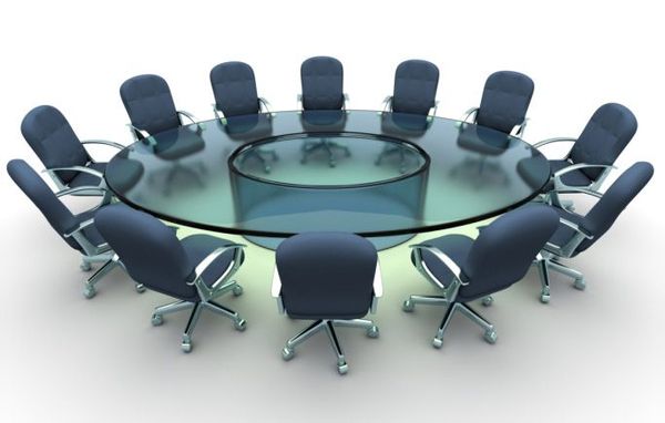 Frosted glass round conference table with 12 navy blue rolling chairs arranged symmetrically in an office setting