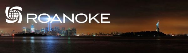 Nighttime NYC skyline with Statue of Liberty, twin blue memorial lights, and Roanoke logo overlaid on dark sky and water