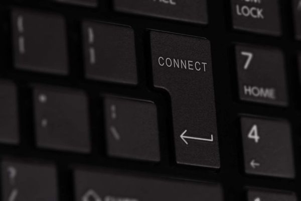 Close-up of a black keyboard with "CONNECT" key highlighted, surrounded by other dark keys like "HOME" and "4"