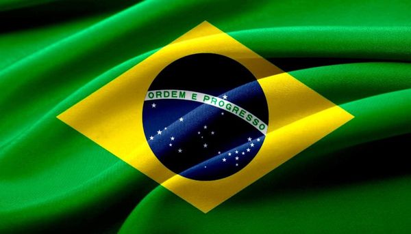 Waving Brazilian flag with vibrant green, yellow, and blue colors, featuring stars and the national motto "Ordem e Progresso"